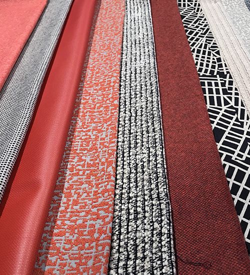 Row of textiles in terra cotta pinks and black-and-white geometrics. Luna Textiles