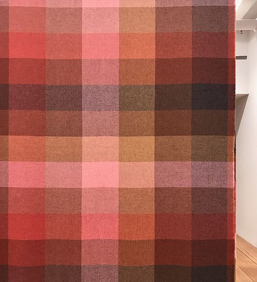 Plaid textile in varying shades of pink, orange, and brown. Maharam