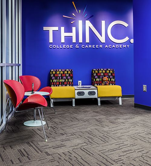 THINC Academy lobby with school logo on a bright blue wall.