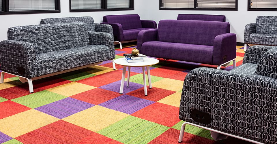 Colorful, flexible learning space with red, yellow, purple, and green carpet tiles.