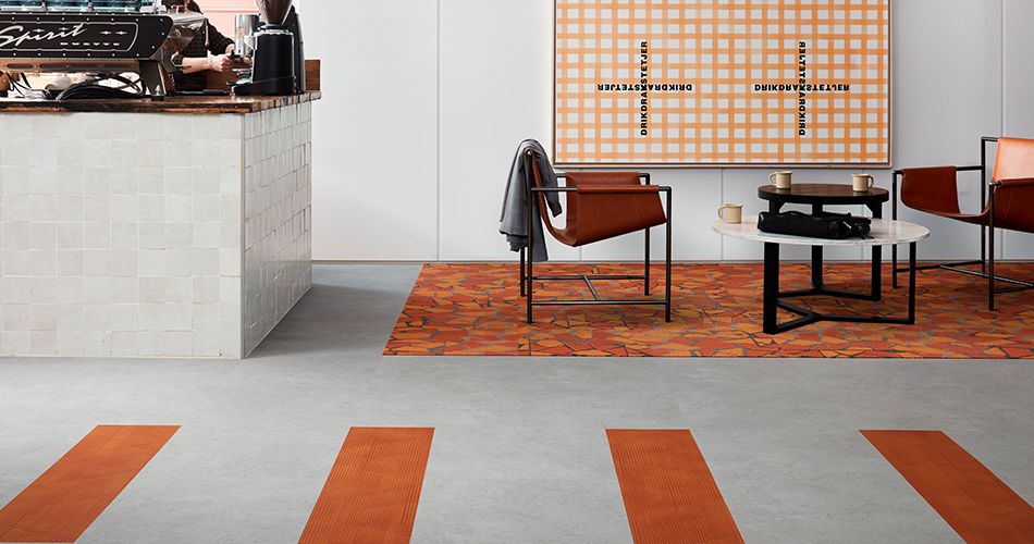 Using orange accents to energise in a hotel cafe. Products: Level Set – Light Concrete, Drawn Lines – Amber, Human Connections Rue - Orange