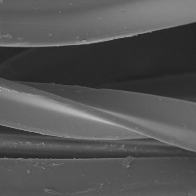 O cumprimento da fibra visto antes de testar com microscópio Scanning Electron: observe vales altos e baixos da superfície.